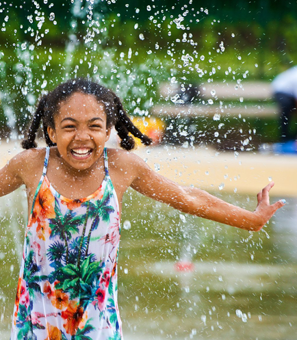 A girl enjoying a splash pool in Cassiobury park