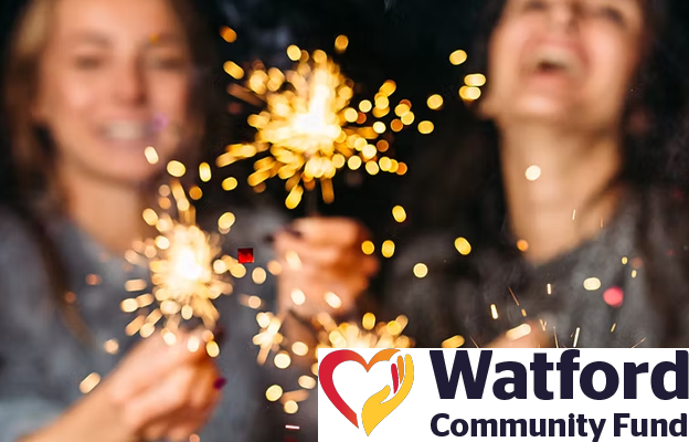 Adults laughing and playing with sparklers