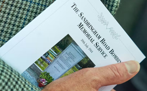 A man holding a cemetery programme