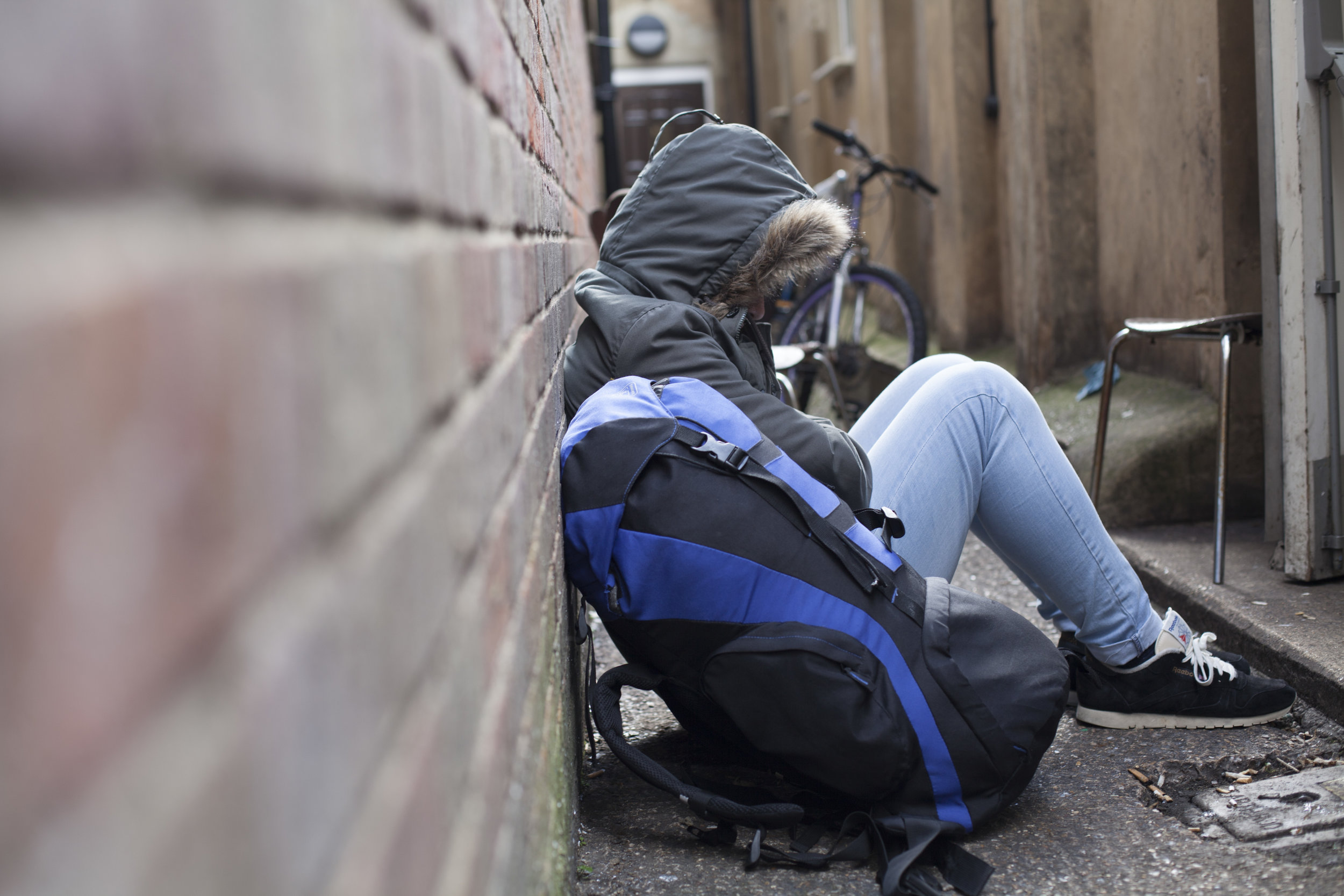 A person sitting against a wall