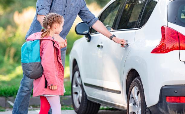 Father meeting daughter and leading her to a white car.